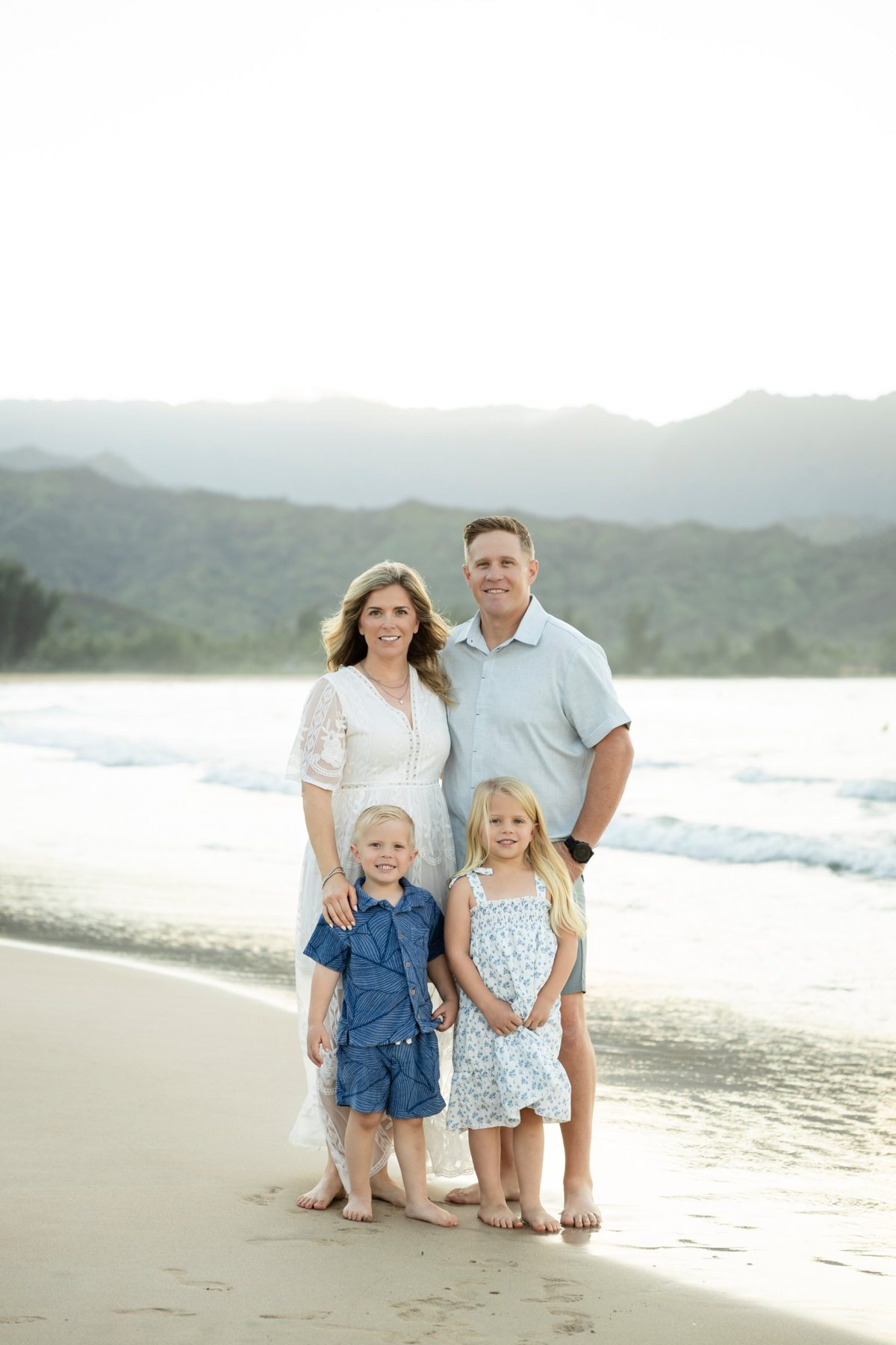 Eric Crowley with his family on a beach, with mountains behind them
