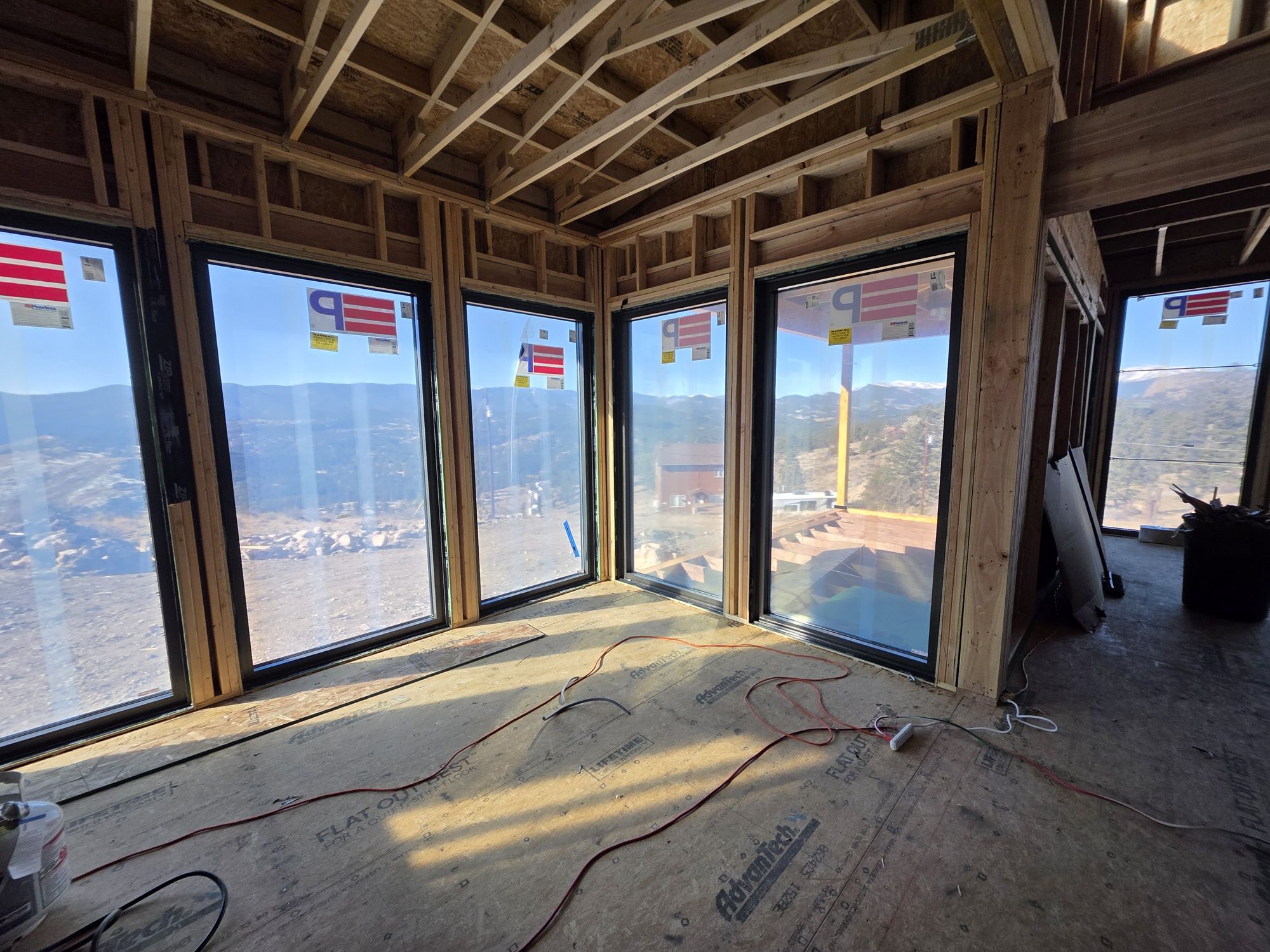 Framed room with a wall of new windows looking out to the valley